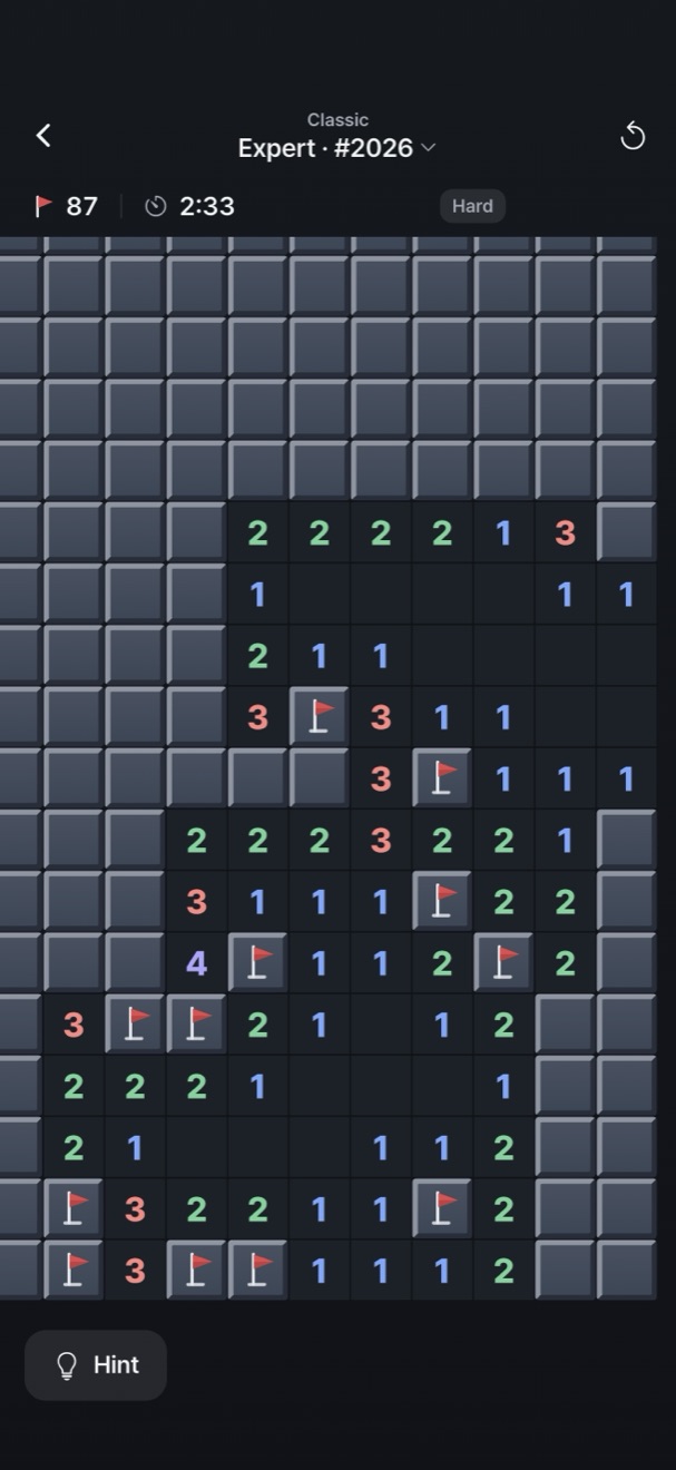 A Classic Expert board in progress on dark slate: raised closed cells, open cells with numbers, and flags. At the top: Expert · #2026, mines left, time and “Hard”.